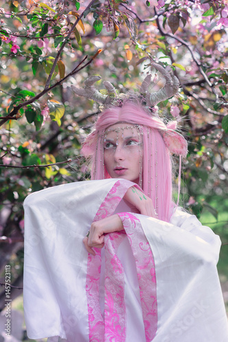 Obraz na płótnie Deer dryad girl against the background of a blooming pink apple tree w salonie