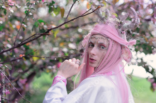 Obraz na płótnie Deer dryad girl against the background of a blooming pink apple tree w salonie