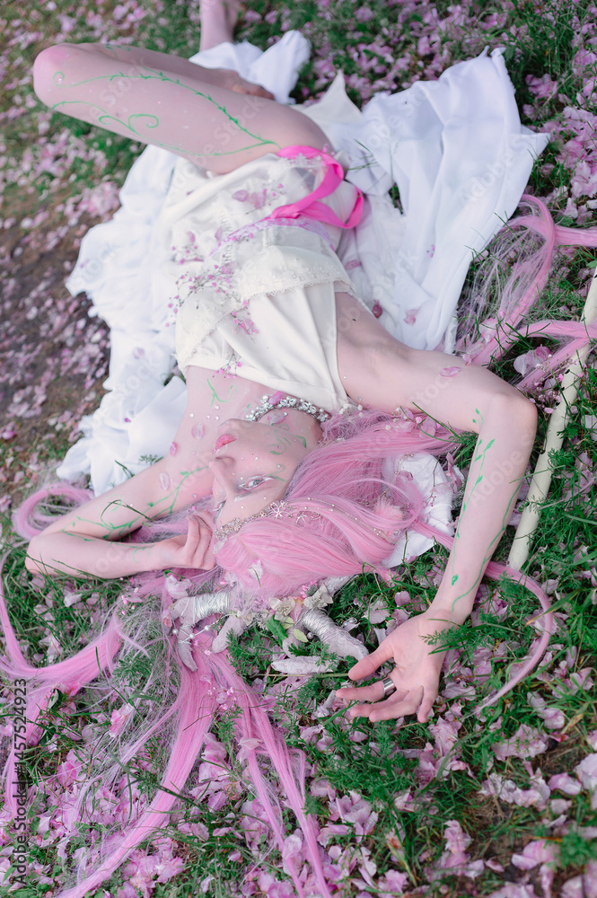 Deer dryad girl against the background of a blooming pink apple tree