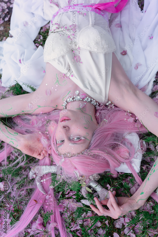 Deer dryad girl against the background of a blooming pink apple tree