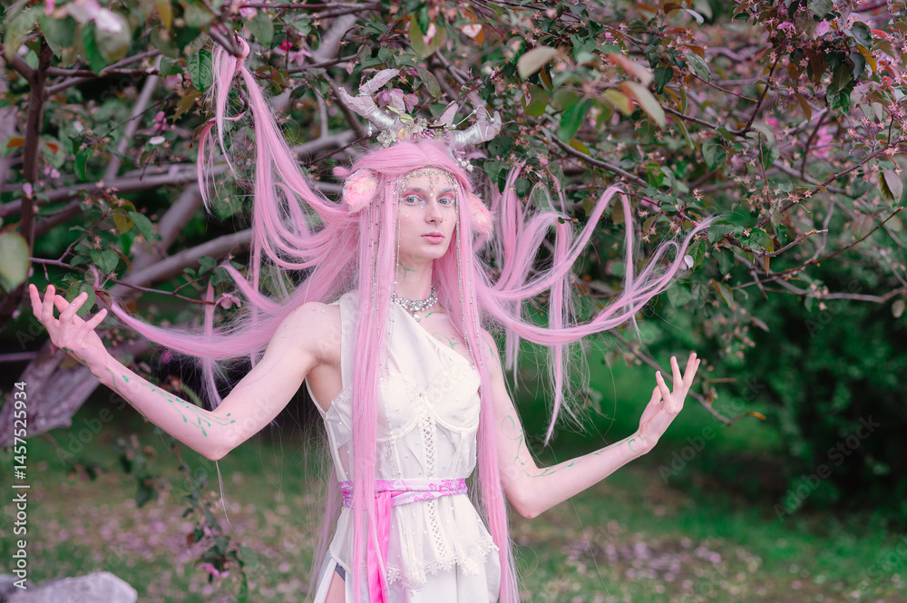 Deer dryad girl against the background of a blooming pink apple tree