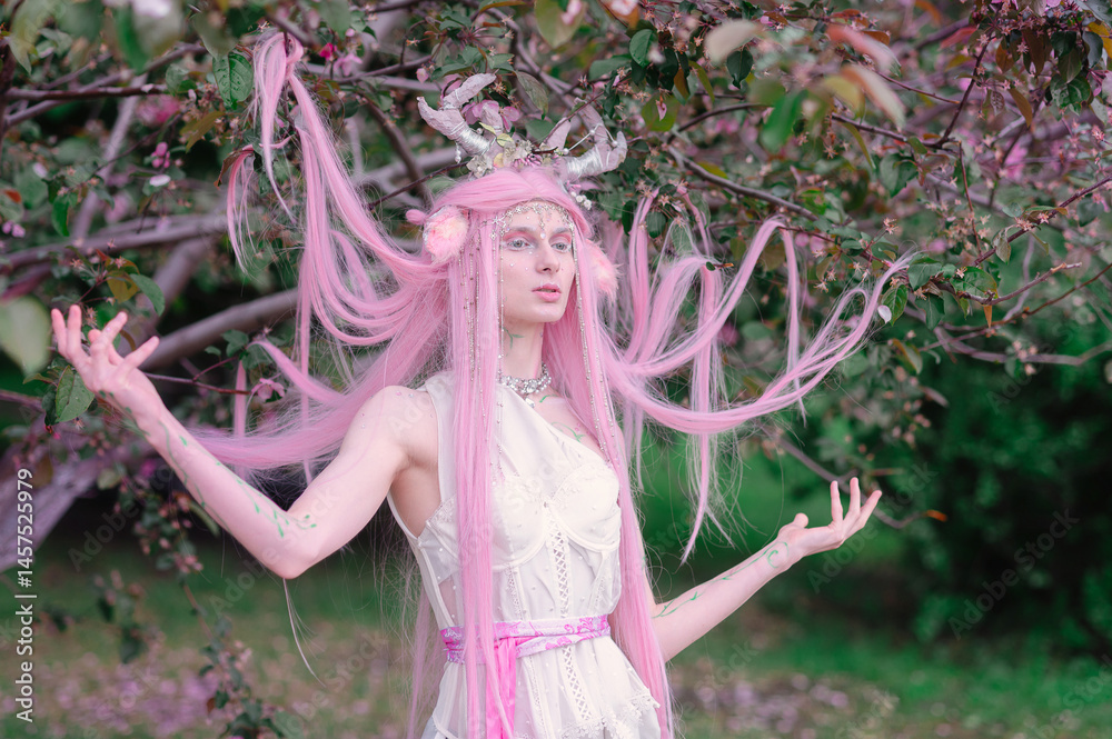 Deer dryad girl against the background of a blooming pink apple tree