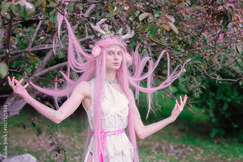 Obraz na płótnie Deer dryad girl against the background of a blooming pink apple tree w salonie