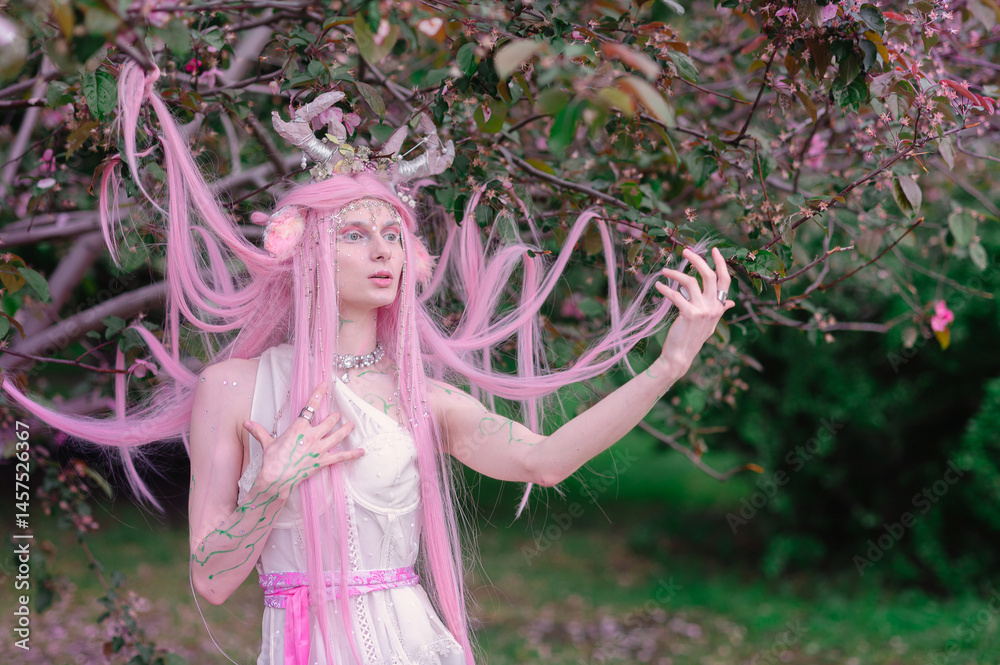 Deer dryad girl against the background of a blooming pink apple tree