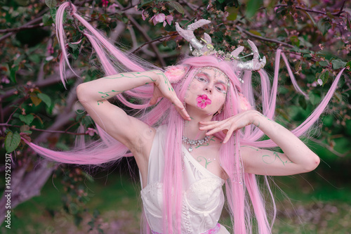 Obraz na płótnie Deer dryad girl against the background of a blooming pink apple tree w salonie
