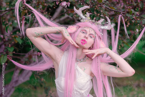 Obraz na płótnie Deer dryad girl against the background of a blooming pink apple tree w salonie