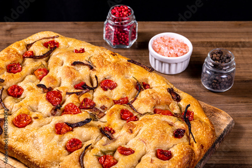 Traditional Italian Focaccia with cherry tomatoes, black olives and rosemary.