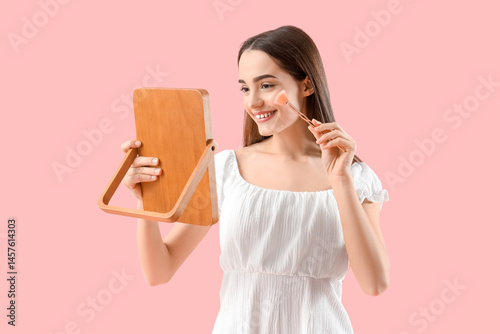 Young woman with mirror doi...