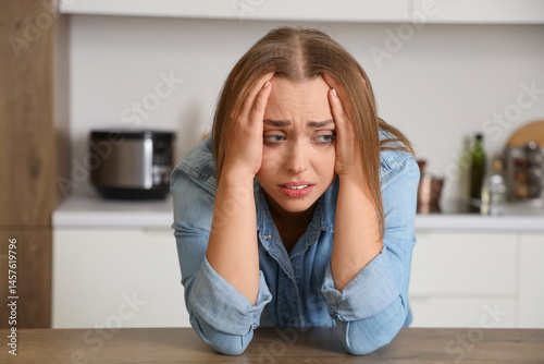 Scared young woman in kitch...