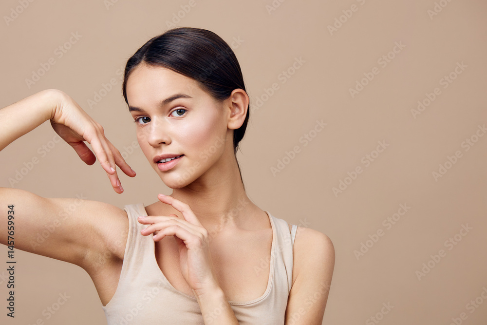 Beautiful young woman with smooth skin posing elegantly against a neutral background, showcasing confidence and natural beauty in a light beige outfit Beautiful young woman with smooth skin posing elegantly against a neutral background, showcasing confidence and natural beauty in a light beige outfit