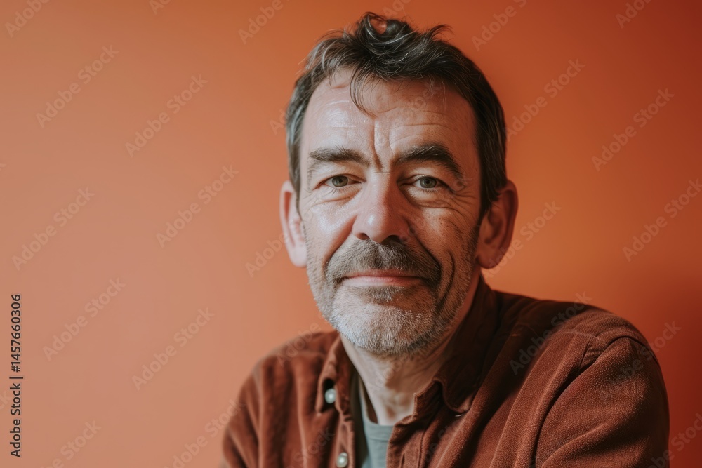 Portrait of mature man with grey beard and mustache on orange background Portrait of mature man with grey beard and mustache on orange background
