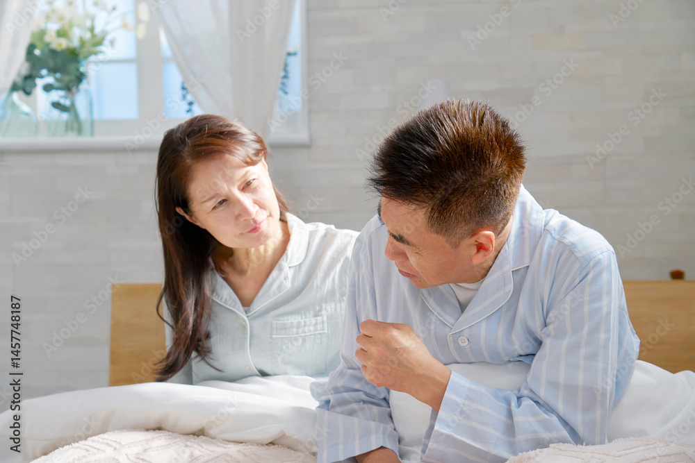 Fototapeta premium ベットの上で咳をする男性