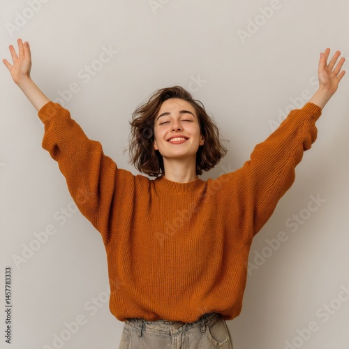 Joyful Woman Embracing Freedom with Arms Raised Towards a Bright Blue Sky in an Open Natural Environment Conveying Happiness and Liberation Feelings photo