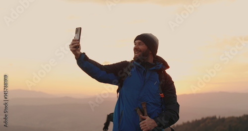Solo traveler standing on a mountainside talking via video call. Remote communication in the wilderness, solitude and technology come together.
