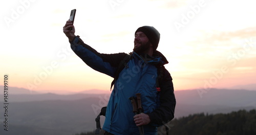 Solo traveler standing on a mountainside talking via video call. Remote communication in the wilderness, solitude and technology come together.