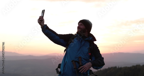 Solo traveler standing on a mountainside talking via video call. Remote communication in the wilderness, solitude and technology come together.