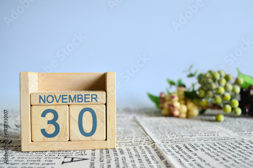November 30, Calendar cover design with number cube with fruit on newspaper fabric and blue background.	