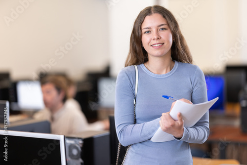 Obraz na płótnie In classroom of information technology school, girl with notebook student is standing near PC workplace. Additional training, advanced training, skill development.. w salonie