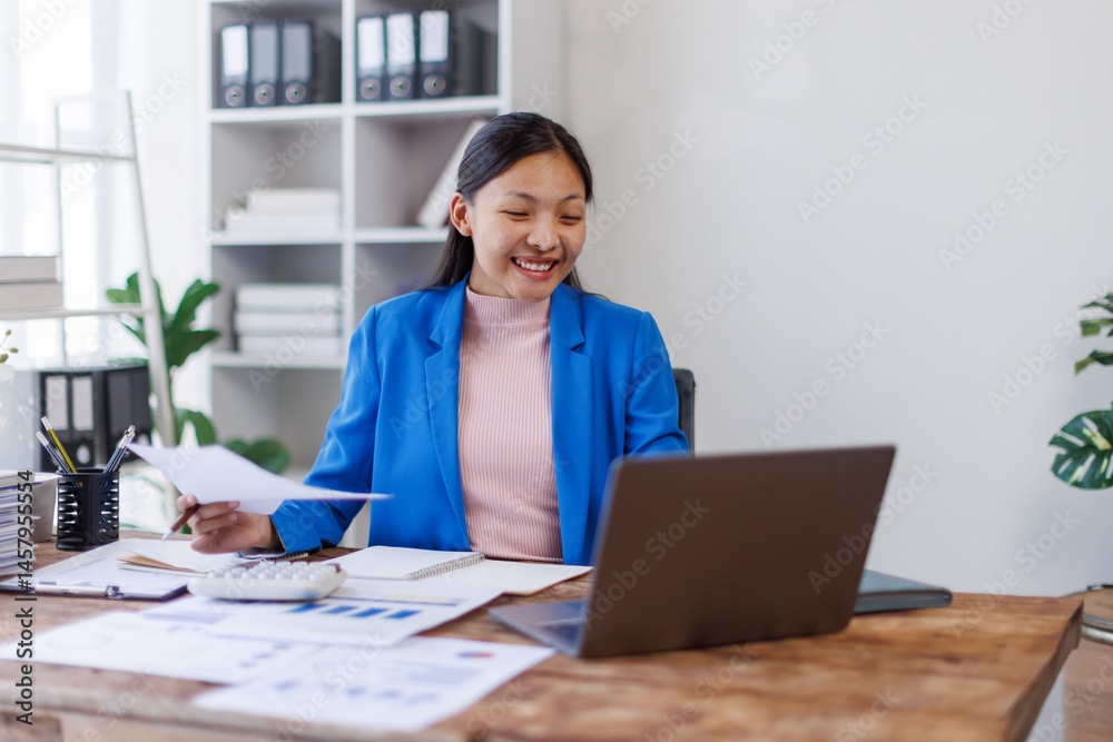 © David - Young business asian woman typing on laptop holding papers preparing report analyzing work results, female executive doing paperwork at workplace using computer for data analysis
