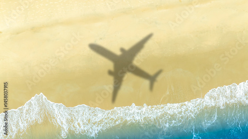 Aerial view of shadow passenger plane silhouette and sandy beach blue sea with waves at sea beach summer vacation sea travel concept	

