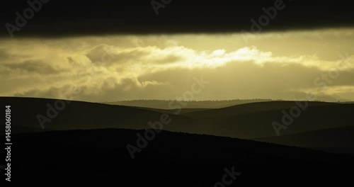 Timelapse of dark clouds and light over the hills