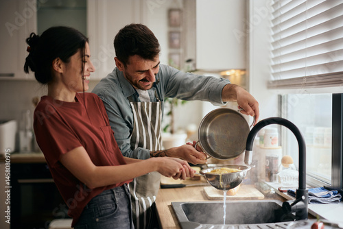 Happy couple having fun while making pasta for lunch. photo