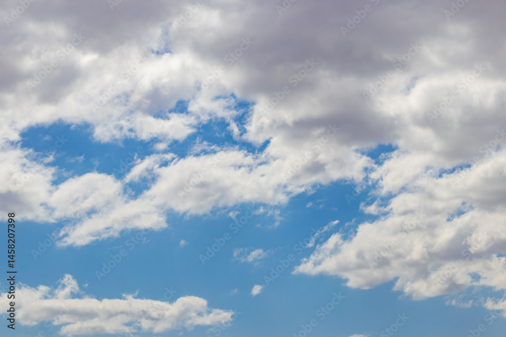 A bright blue sky with fluffy white clouds on a sunny day A bright blue sky with fluffy white clouds on a sunny day