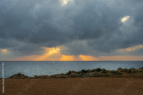 Sunset on the rocky coastline in Peyia, Cyprus. Striking natural contrasts and tranquil atmosphere make this place ideal for travel, nature and relaxation. photo