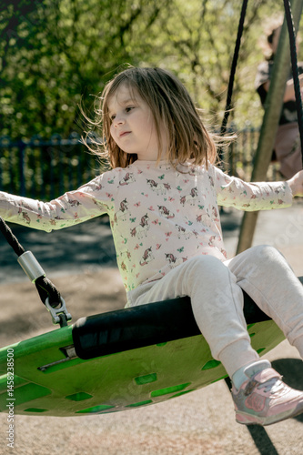 Toddler girl on swing, playground. Education, activity outdoor