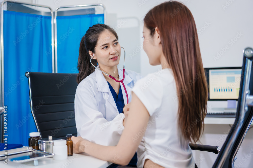 Fototapeta premium An Asian woman sits at a table consulting with a female doctor. They discuss her symptoms related to stress and depression. The doctor listens attentively and recommends treatment and medication