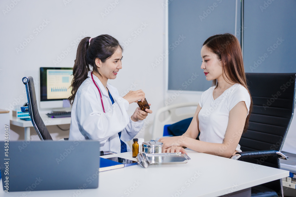 An Asian woman sits at a table consulting with a female doctor. They discuss her symptoms related to stress and depression. The doctor listens attentively and recommends treatment and medication An Asian woman sits at a table consulting with a female doctor. They discuss her symptoms related to stress and depression. The doctor listens attentively and recommends treatment and medication