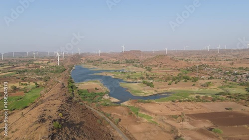 Beautiful aerial view of so many wind mills, agriculture land and river water located near Nandurbar City in Maharashtra state, India.