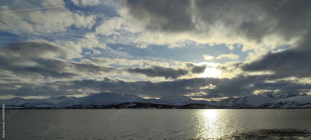 Obraz premium Beautiful photography of a nice sunset in the city of Tromsø, Norway, right before the midnight sun, with a nice reflection over the sea.