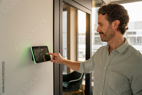 Man using a tablet to book an office in a modern workspace