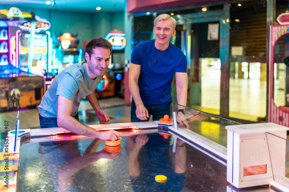 Friends playing air hockey in entertainment center