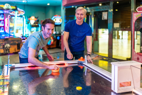 Obraz na płótnie Friends playing air hockey in entertainment center w salonie