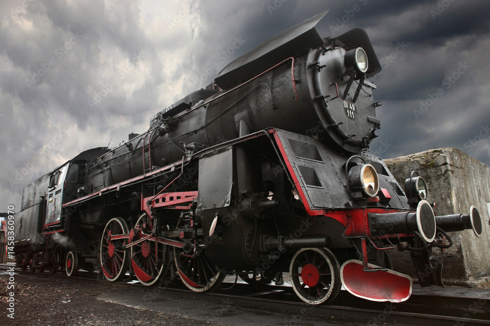 Obraz premium Powerful steam locomotive against a stormy sky, intricate details and historical significance