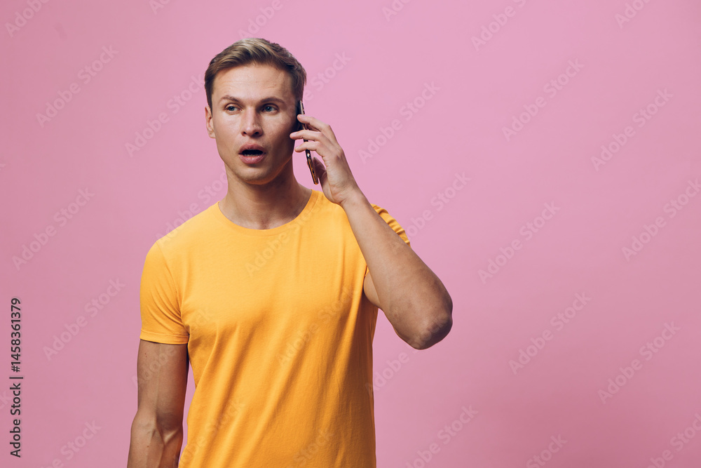 surprised man talking phone chat with AI digital communication smartphone against pink background casual yellow t-shirt young caucasian surprised man talking phone chat with AI digital communication smartphone against pink background casual yellow t-shirt young caucasian