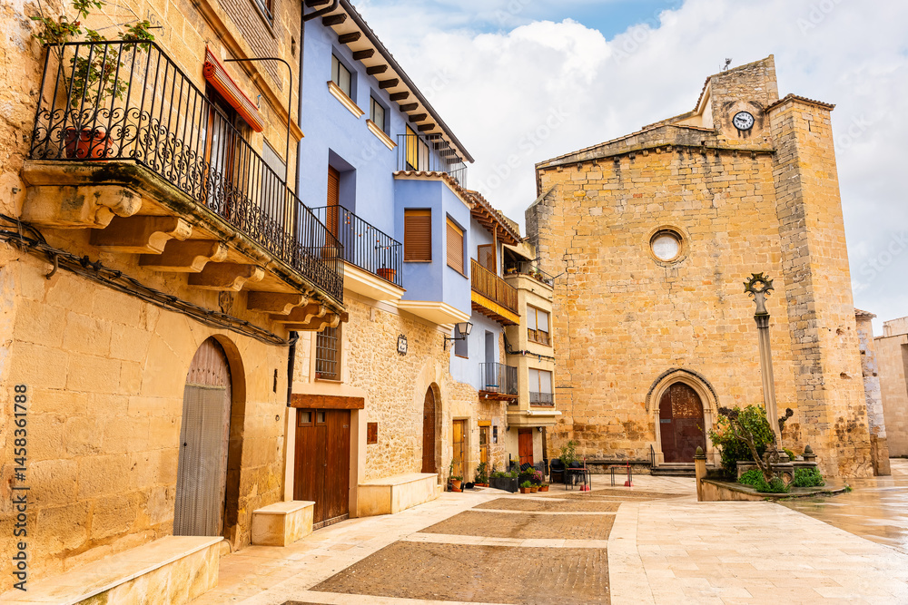 Main square with old stone church in the medieval village of Matarrana, Teruel.