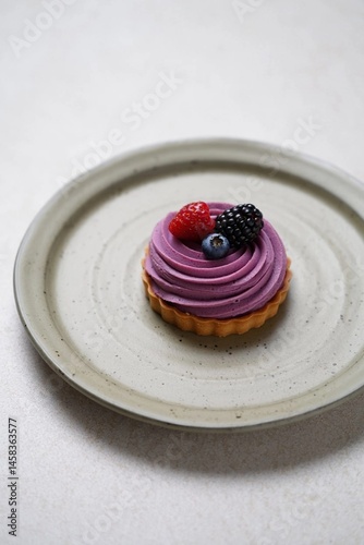 Delicious berry tart on a neutral plate showcasing creamy frosting with vibrant fruit toppings Generative AI
