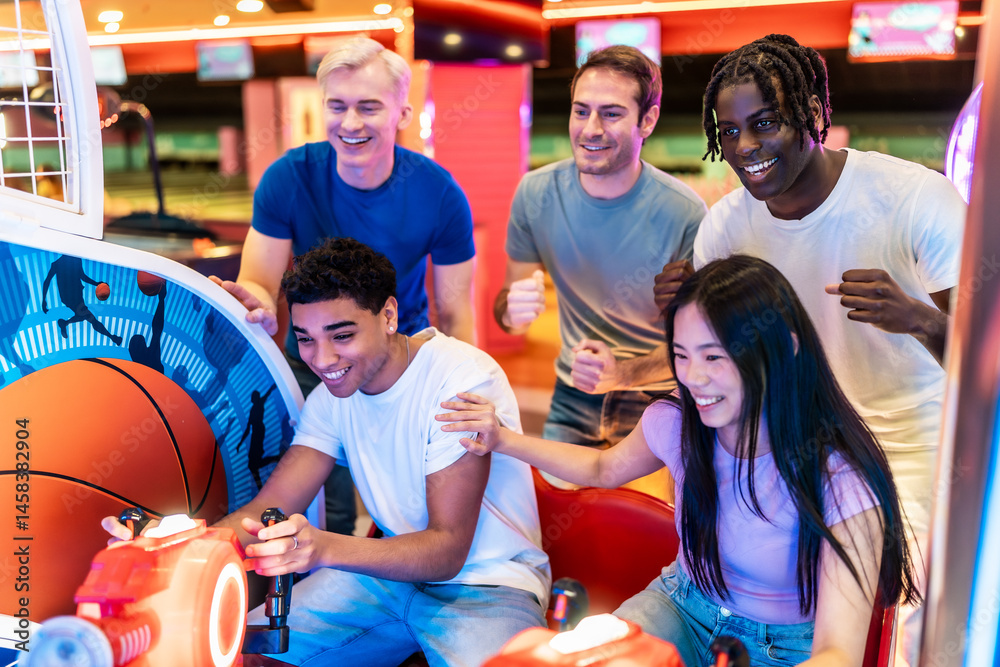 Happy multiethnic friends playing arcade basketball game together