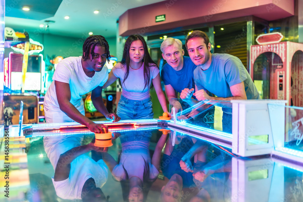 Group of friends playing air hockey in entertainment center