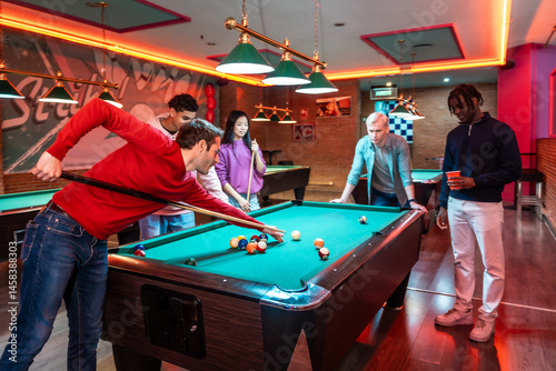 Friends playing billiards in entertainment venue
