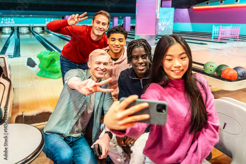 Obraz na płótnie Happy multi ethnic friends taking selfie and gesturing peace sign at bowling alley w salonie