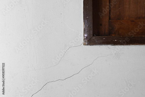 Small hair crack or  damage on concrete wall at corner window. Problem issue from low quality concrete, old, weathered or earthquake. Need repair by epoxy filler for flat smooth.