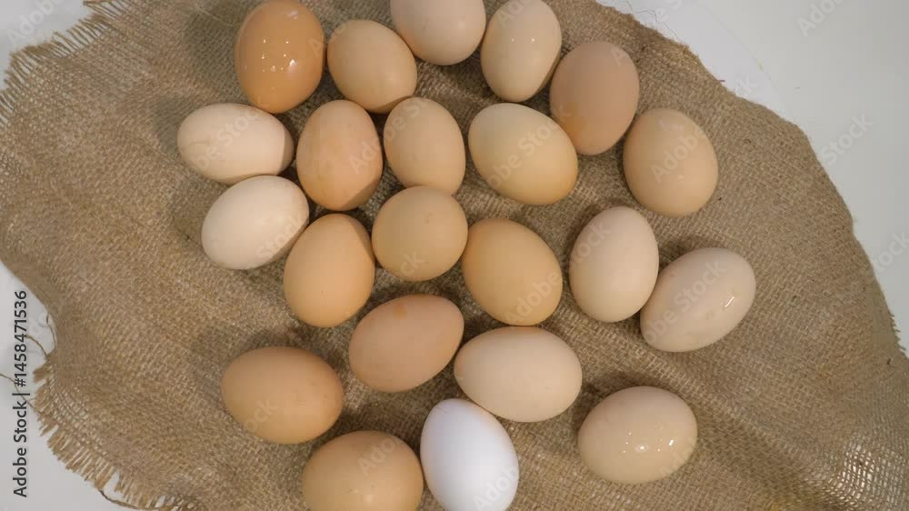 op view. Many chicken eggs in shells on a farm bag, on a turntable. Hard-boiled chicken eggs. Slow motion op view. Many chicken eggs in shells on a farm bag, on a turntable. Hard-boiled chicken eggs. Slow motion