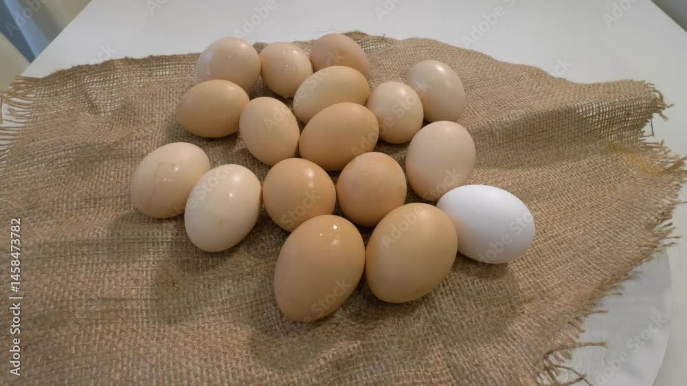 Many chicken eggs in shells on a farm bag, on a turntable. Hard-boiled chicken eggs. Slow motion. Many chicken eggs in shells on a farm bag, on a turntable. Hard-boiled chicken eggs. Slow motion.