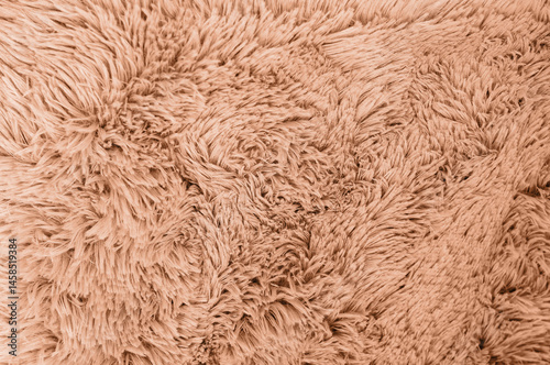 A close-up shot showing the intricate details of a plush, fluffy, brown fabric texture.