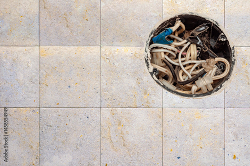Obraz na płótnie Open electrical box displays a tangle of wires and connectors set against a neutral tiled wall. w salonie