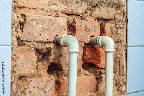 Obraz na płótnie Close-up of exposed brick and pipes in a bathroom under renovation showing construction elements. w salonie